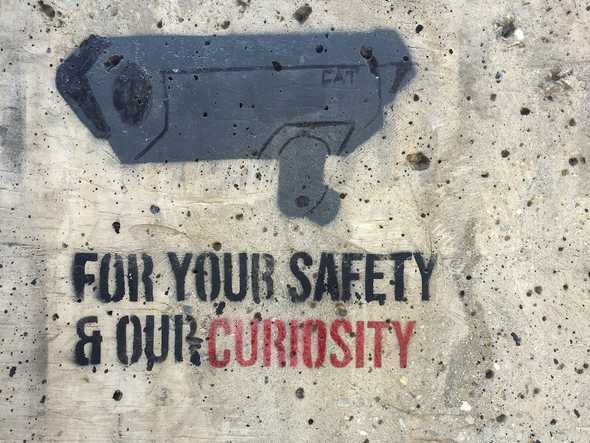 Security camera stencil with text on wall